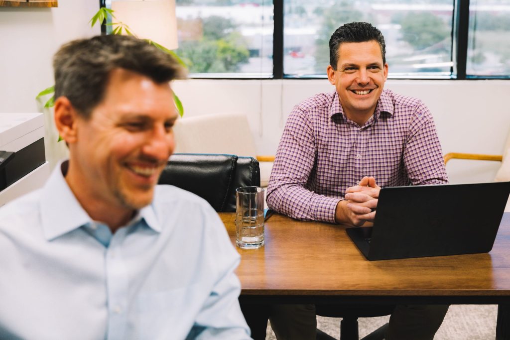 2 coworkers at Stepping Forward Technology, a business-aligned MSP in Colorado Springs, working and smiling